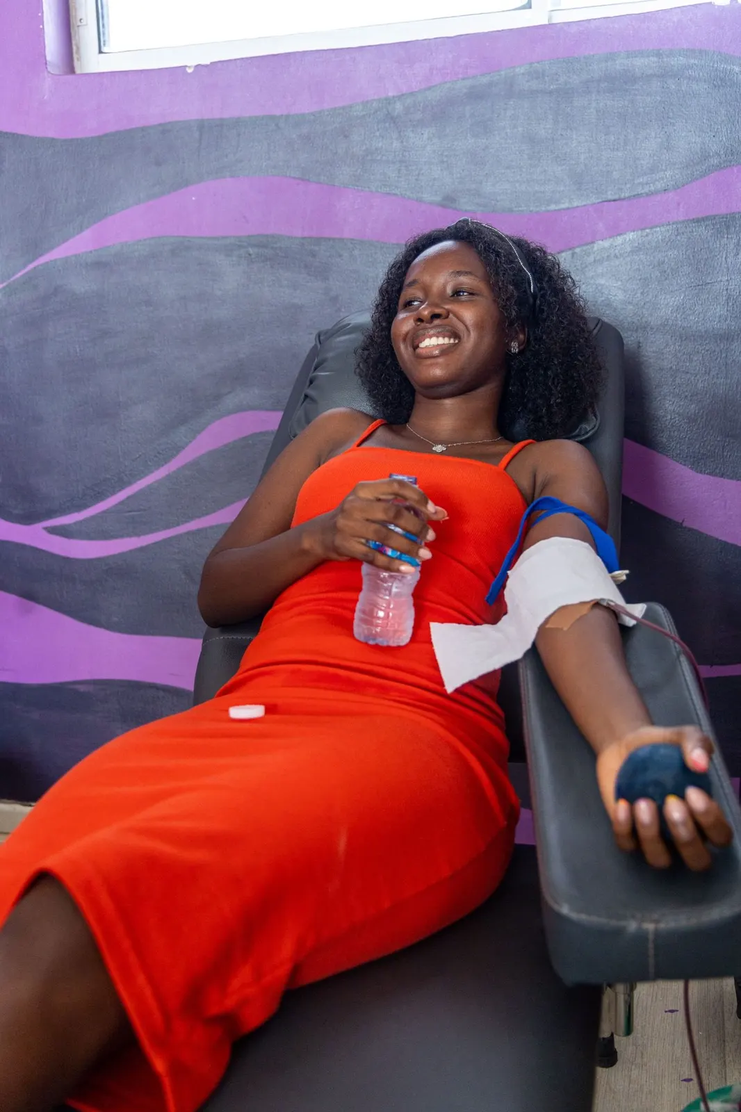 A donor smiling brightly while giving blood at a OnePint Plus drive